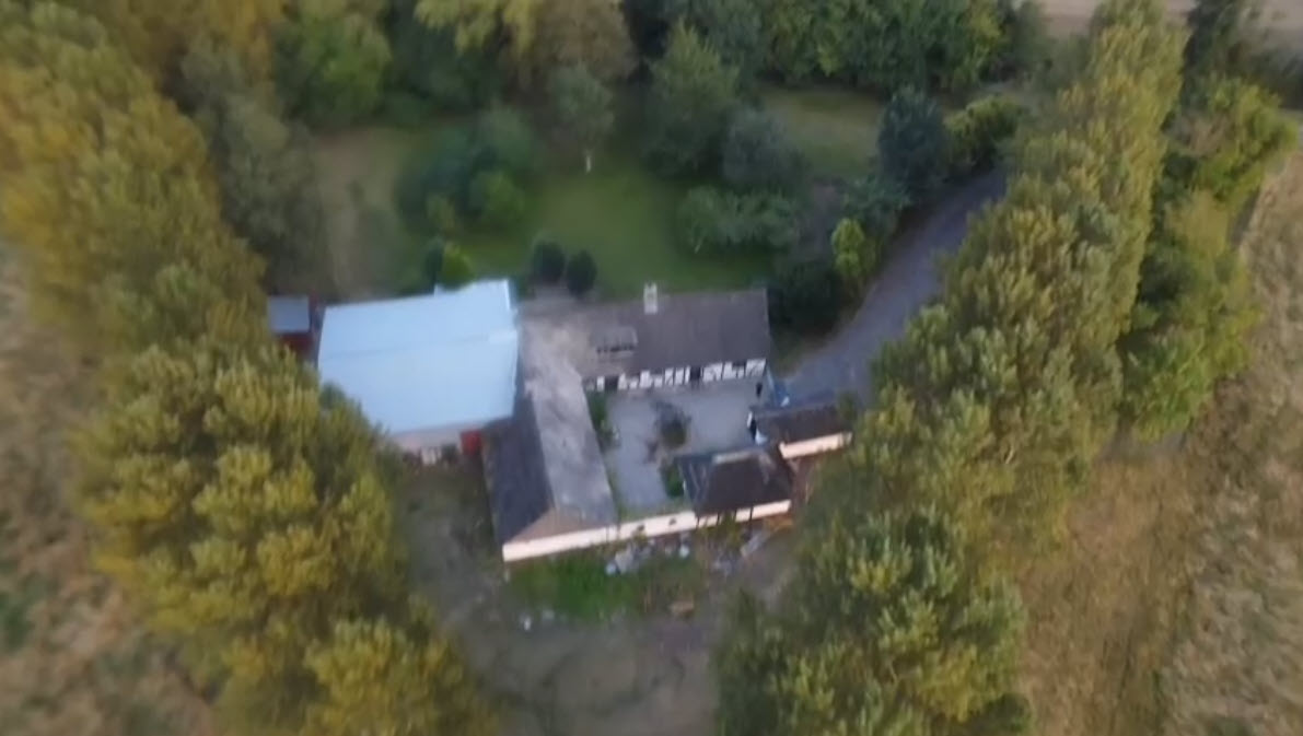 Aerial view of Holeby Rejsestald farmstead among green trees
